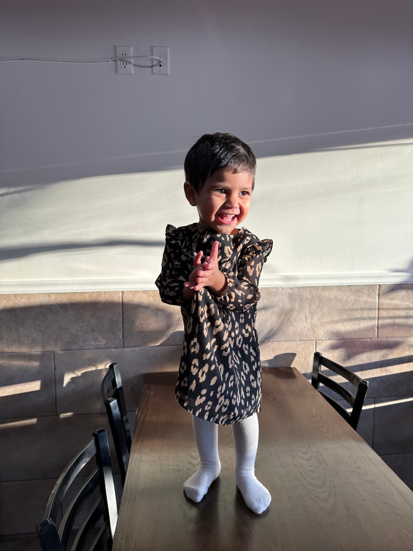 Faatiha laughing in a leopard dress